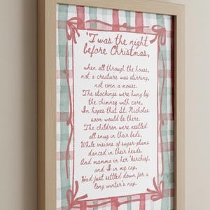 May include: Framed print featuring the poem "Twas the Night Before Christmas." The text is in a handwritten style, with a red and white plaid background and a light wood frame. A festive holiday decoration.