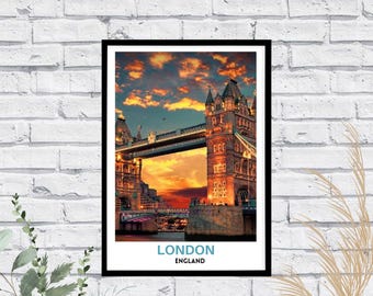 May include: A framed wall art print featuring a sunset view of Tower Bridge in London, England. The image displays the bridge towers and suspension structure against a vibrant orange and blue sky. The text LONDON ENGLAND is printed at the bottom.
