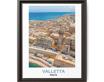 May include: A framed wall art print featuring an aerial view of Valletta, Malta, with its historic stone buildings, a prominent church tower, and the blue Mediterranean Sea. The text VALLETTA MALTA is printed in blue and black at the bottom.