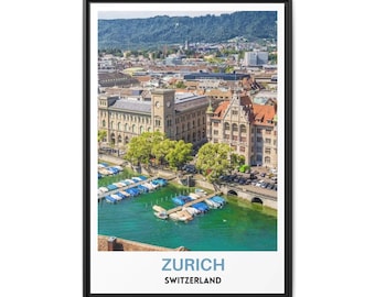 May include: A framed wall art print featuring an aerial view of Zurich, Switzerland, with a turquoise river, docked boats, historic stone buildings, and green trees. The bottom white border displays the text ZURICH SWITZERLAND in blue and black.