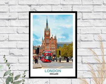 May include: A framed wall art print featuring a red double-decker bus driving past the St. Pancras Renaissance Hotel in London, England. The print includes the text LONDON in large blue letters and ENGLAND in smaller black letters at the bottom.
