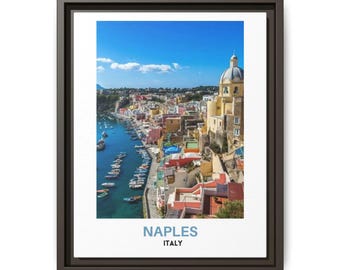 May include: A framed wall art print featuring a coastal cityscape of Naples, Italy, with colorful buildings, a harbor filled with small boats, and a clear blue sky. The text NAPLES ITALY is printed in blue and black at the bottom of the white border.