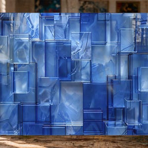 Puede incluir: Obra de arte abstracta de vidrio azul con un dise&ntilde;o geom&eacute;trico de formas rectangulares y cuadradas superpuestas. La obra de arte tiene una calidad transl&uacute;cida, con diferentes tonos de azul y toques de blanco, creando un efecto tridimensional. La pieza se exhibe sobre una superficie de madera.