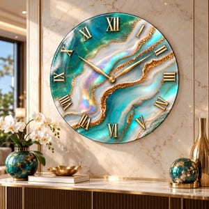 May include: A round wall clock featuring a swirling teal, white, and gold marbled pattern on its face. The clock has gold-colored Roman numerals and matching gold-colored hour and minute hands centered on the dial, creating a cohesive look.