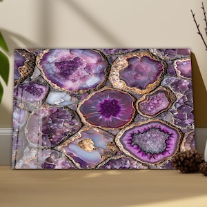 Könnte beinhalten: Nahaufnahme einer dekorativen Platte mit einem Mosaik aus Amethyst-Geoden. Die Geoden sind in Lila-, Lavendel- und Weißtönen gehalten und haben goldfarbene Ränder. Die Platte ist rechteckig und hat eine glänzende Oberfläche.
