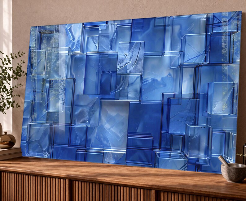Puede incluir: Arte mural abstracto azul con un dise&ntilde;o geom&eacute;trico 3D. La obra de arte est&aacute; compuesta por formas rectangulares superpuestas en diferentes tonos de azul, creando un efecto texturizado y en capas. La pieza est&aacute; montada sobre una superficie de madera.