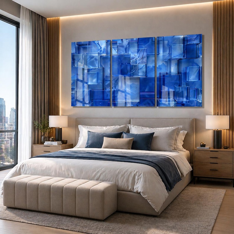 Puede incluir: Un dormitorio moderno con una cama grande y un banco tapizado beige. Encima de la cama, un tr&iacute;ptico de arte abstracto azul cuelga de la pared. La habitaci&oacute;n tiene grandes ventanas y detalles de madera.
