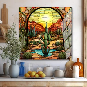 May include: A stained glass art piece depicting a desert landscape with cacti, mountains, and a small pool of water. The artwork features a vibrant color palette of greens, oranges, and yellows, framed by a dark archway.