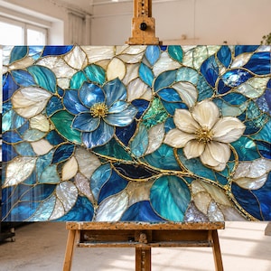 Pode incluir: Uma obra de arte em vitral apresentando duas flores grandes, uma azul profunda e outra branca, rodeadas por um padrão denso de folhas azuis, turquesas e brancas. A composição é unida por finas linhas de metal dourado.