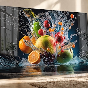 Könnte beinhalten: Ein lebendiger Kunstdruck, der einen Wasserspritzer mit verschiedenen Früchten zeigt. Orangen, Äpfel, Erdbeeren und Trauben sind in der Luft schwebend dargestellt, mit Wassertropfen und einem dunkelblauen Hintergrund. Das Kunstwerk wird auf einer Leinwand mit Rahmen präsentiert.