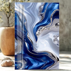 May include: Abstract art print with a fluid design in blue, silver, and white. The artwork has a glossy finish and a modern aesthetic. The composition includes flowing, marbled patterns with metallic accents.