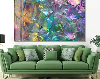 May include: Abstract wall art featuring a close-up of iridescent, textured shapes in shades of purple, green, and gold. The artwork is displayed above a green sofa with various throw pillows.