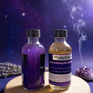 Könnte beinhalten: Zwei Glasflaschen mit Blissful Truth Öl, eine mit violetter Flüssigkeit und die andere mit bernsteinfarbener Flüssigkeit, stehen auf einem Holztablett. Die Flaschen haben schwarze Kappen und Etiketten mit Text. Der Hintergrund ist dunkelblau mit Raucheffekt.
