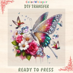 May include: A colorful DTF transfer design featuring a jeweled butterfly with vibrant wings, surrounded by pink roses, white daisies, and hummingbirds. The design includes the text "ColorWhisper DTF TRANSFER" and "READY TO PRESS".