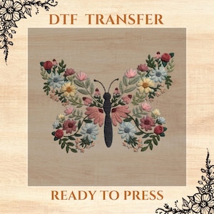 May include: A ready-to-press iron-on transfer featuring a floral butterfly design. The butterfly is made of pink, white, and green flowers with a dark gray outline. The text "DTF TRANSFER" is at the top of the image and "READY TO PRESS" is at the bottom.