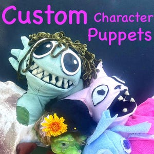Może przedstawiać: Kolekcja niestandardowych kukiełek postaci w różnych kolorach. Kukiełki obejmują jasnoniebieskiego potwora z dużymi zębami, różowego potwora, zieloną kukiełkę w kształcie wiedźmy z żółtym kwiatem i niebieską kukiełkę z dużymi oczami. Widoczny jest tekst "Custom character Puppets".