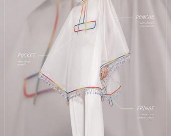 May include: A translucent white hooded poncho featuring a rainbow-coloured trim, a front flap pocket, and an iridescent beaded fringe along the hem. The garment includes labels identifying the hood, poncho, pocket, and fringe details.