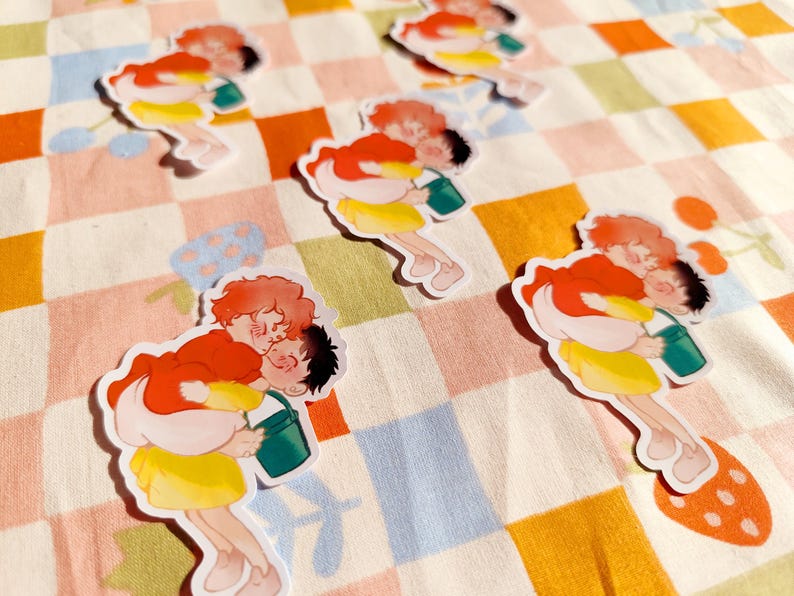 Puede incluir: Cuatro pegatinas coloridas con parejas de dibujos animados que sostienen cubos. Las pegatinas est&aacute;n sobre un fondo a cuadros.