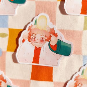 Puede incluir: Una pegatina con un personaje de dibujos animados con cabello rosado que lleva un abrigo blanco y esponjoso y sostiene un cubo verde. El personaje tiene un objeto amarillo en la cabeza y sonr&iacute;e.