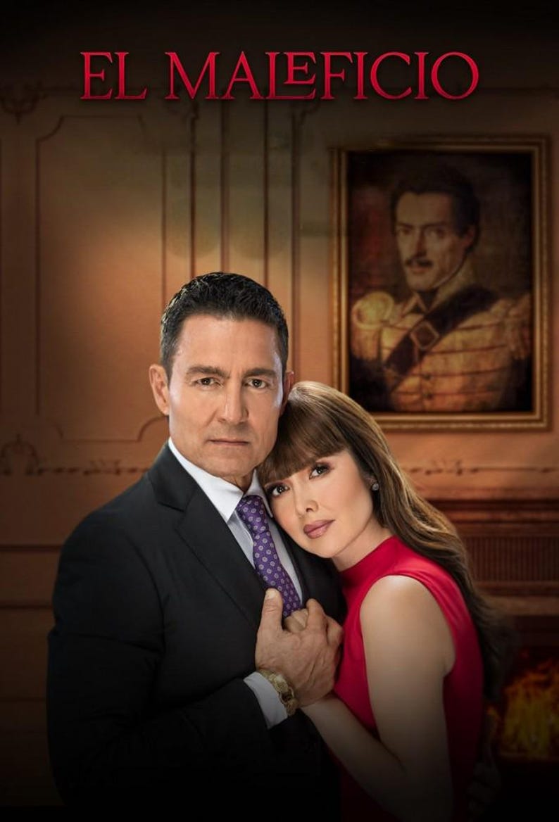 K&ouml;nnte beinhalten: Ein Paar in romantischer Umarmung, der Mann in einem schwarzen Anzug und einer lila Krawatte, die Frau in einem roten Kleid. Der Titel "EL MALEFICIO" ist in roten Buchstaben oben im Bild dargestellt.