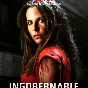 Peut inclure: Une femme aux longs cheveux bruns regarde intensément la caméra. Elle porte une chemise rouge et a une blessure sanglante au bras. Le texte "INGOBERNABLE" est en bas de l'image.