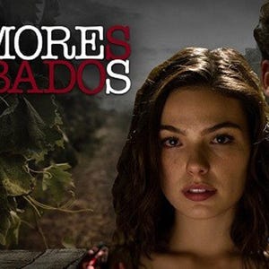 Könnte beinhalten: Ein Plakat für die Telenovela "Amores Robados" mit einer Frau und einem Mann, die in die Kamera schauen. Der Titel der Show ist in großen weißen Buchstaben vor einem dunklen Hintergrund.