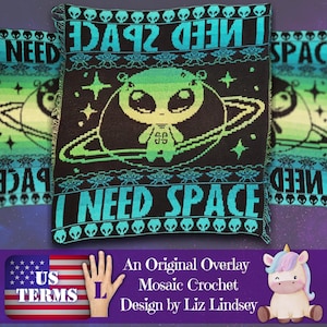 May include: A black, teal, and green crochet blanket with the words "I NEED SPACE" and an alien design. The blanket features a large alien character inside a planet ring, surrounded by stars and UFOs. The design is repeated across the blanket.