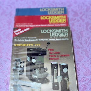 May include: A stack of vintage "Locksmith Ledger" magazines. The top magazine is blue, the middle one is red, and the bottom one has a cover featuring security equipment and the text "SECURITY 777".