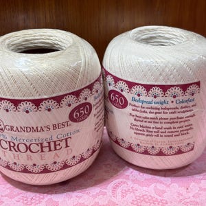 May include: Two spools of Grandma's Best crochet thread. Each spool is wrapped in a label with the text "650 Yards" and "100% Mercerized Cotton CROCHET THREAD". The labels also state the thread is perfect for bedspreads, doilies, and tablecloths.