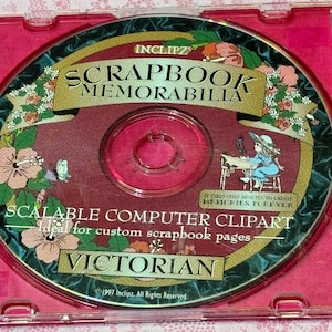 May include: A CD-ROM for scrapbook projects. The disc features the text "SCRAPBOOK MEMORABILIA" and "SCALABLE COMPUTER CLIPART VICTORIAN." The disc has a burgundy background with floral and butterfly accents. The CD is in a pink jewel case.