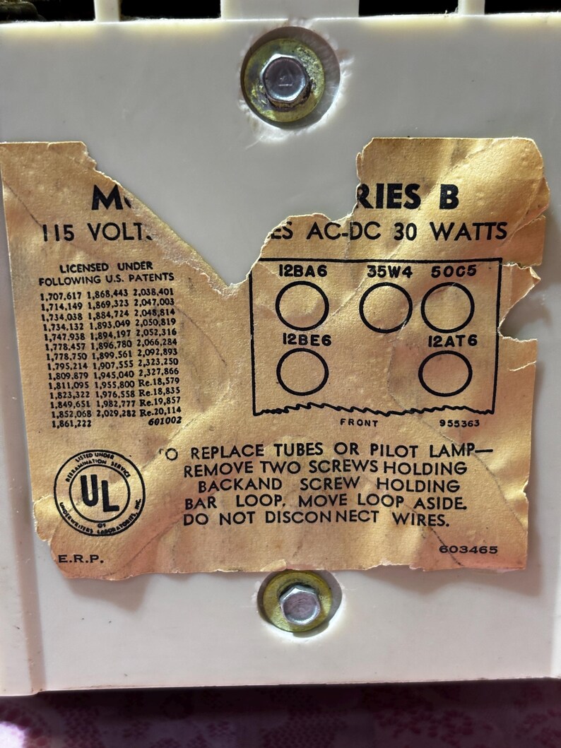 May include: Close-up of a vintage electronic component label. The label is tan with black text, including "115 VOLT" and "SERIES B AC-DC 30 WATTS." It lists tube types and instructions for replacement. The UL logo is visible.