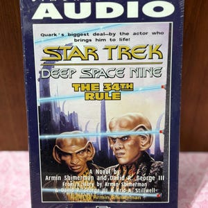 May include: A sealed audio cassette of Star Trek: Deep Space Nine, "The 34th Rule," by Simon & Schuster. The cover features images of two alien characters and the text "Presented on Two Cassettes."