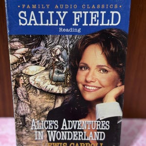 May include: A Family Audio Classics audiobook of "Alice's Adventures in Wonderland" by Lewis Carroll, read by Sally Field. The cover features a portrait of Sally Field and an illustration of Alice in Wonderland.