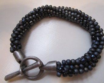 Gray and black kumihimo beaded braided bracelet with antique silver toggle clasp