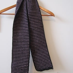 A sheer and blacks with a solid black border. feathery light stylishly striped scarf of cranberry red shades of grays