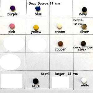 May include: A grid display of circular snap fasteners in various colors including purple, blue, navy, pink, yellow, cream, silver, copper, dark antique silver, black, and white. Text labels indicate Snap Source 11 mm and Scovill 12 mm sizes.