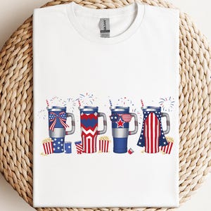 a white t - shirt with fireworks and stars on it