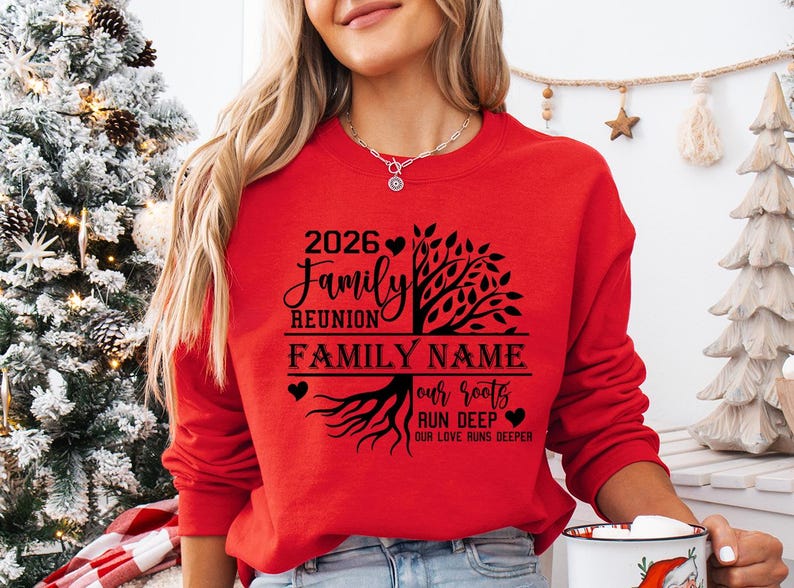 A woman wearing a red sweater with a tree design and text on it, standing in front of a Christmas tree.
