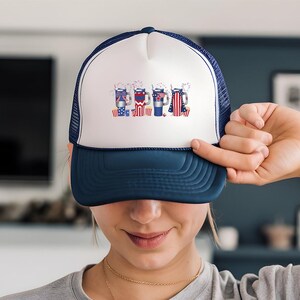 a woman holding up a hat with a picture on it