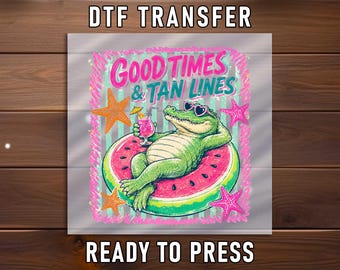 May include: A DTF transfer sheet featuring a graphic of a green alligator wearing pink sunglasses, lounging on a watermelon slice float while holding a pink cocktail. The text reads GOOD TIMES & TAN LINES, surrounded by orange and pink starfish.
