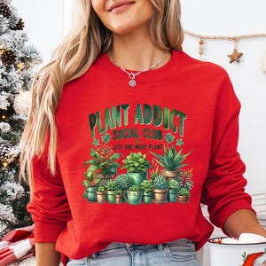 a woman in a red sweatshirt holding a coffee mug