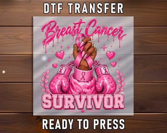 May include: A DTF transfer sheet featuring a graphic design with the text Breast Cancer SURVIVOR. The illustration shows a pair of pink boxing gloves and a hand holding a pink awareness ribbon, surrounded by pink hearts and decorative elements.