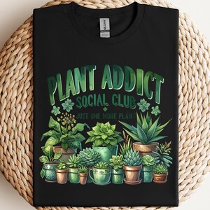 a black t - shirt that says plant addict social club with potted plants