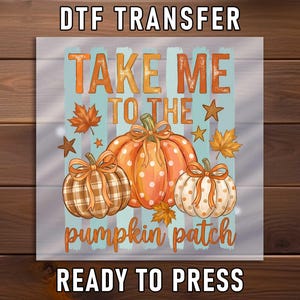 May include: A DTF transfer sheet featuring the text TAKE ME TO THE pumpkin patch READY TO PRESS. The design includes three pumpkins with bows, one with a plaid pattern and two with polka dots, surrounded by orange maple leaves and stars.
