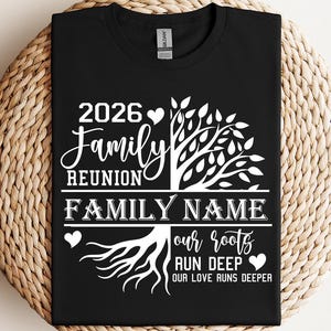 A black t-shirt with a white graphic design featuring a tree with roots and the text "2026 Family Reunion Family Name our roots run deeper".