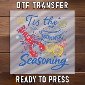 May include: DTF transfer design featuring a red lobster, a pot with the word "SUMMER", and the text "Tis the Seasoning". The design includes lemons, a starfish, and seashells. The words "DTF TRANSFER" and "READY TO PRESS" are also included.