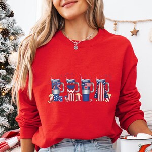 a woman in a red sweater holding a cup of coffee
