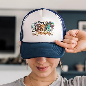 a woman holding a hat with the word happy birthday written on it