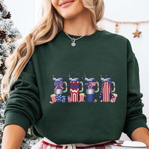 a woman wearing a green sweatshirt with american symbols on it