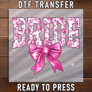 May include: A DTF transfer design featuring the word "BRIDE" in large, pink, floral-patterned letters. A pink bow is below the word. The words "DTF TRANSFER" and "READY TO PRESS" are above and below the design, respectively.